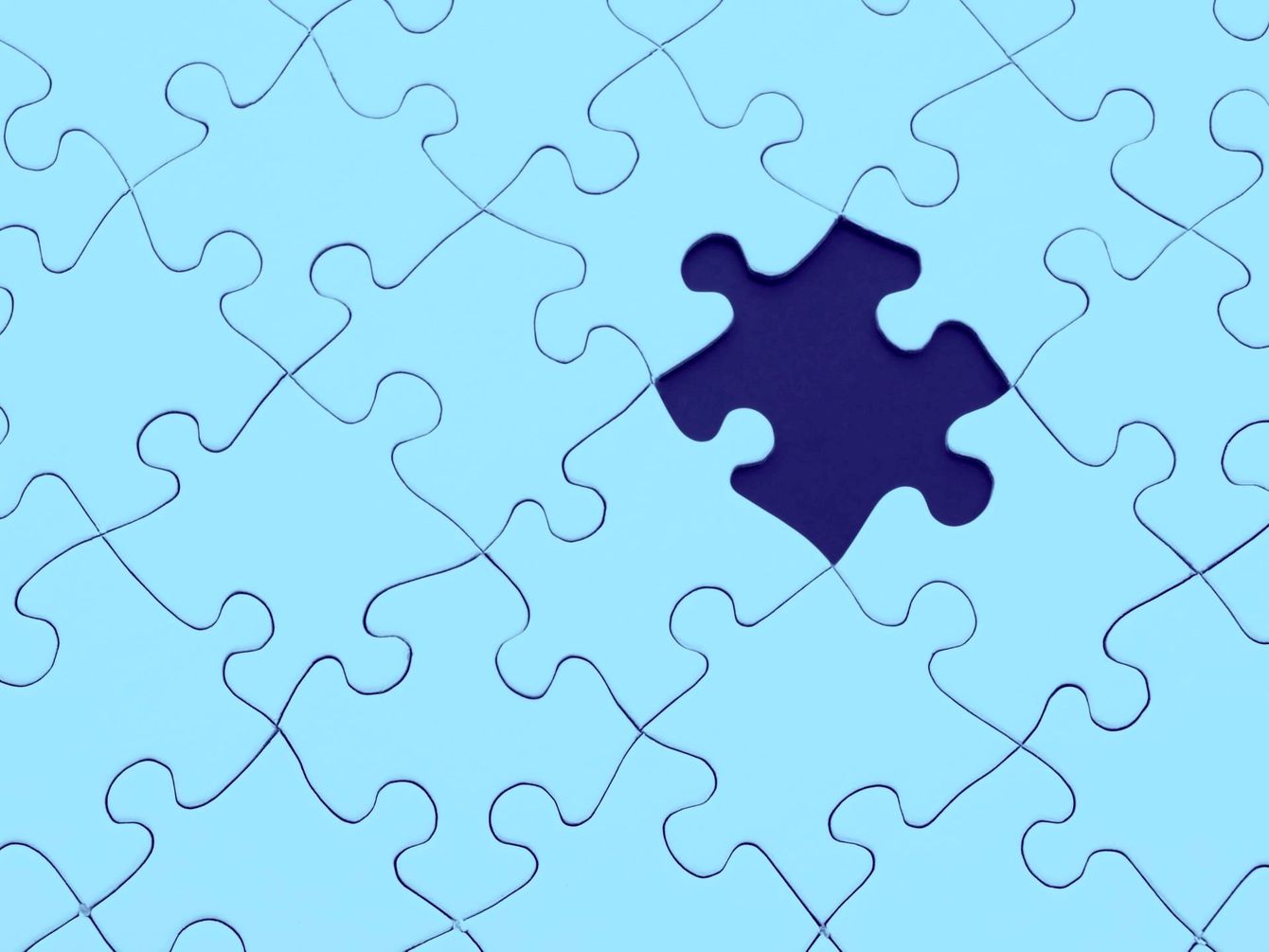 A blue puzzle with a purple piece missing