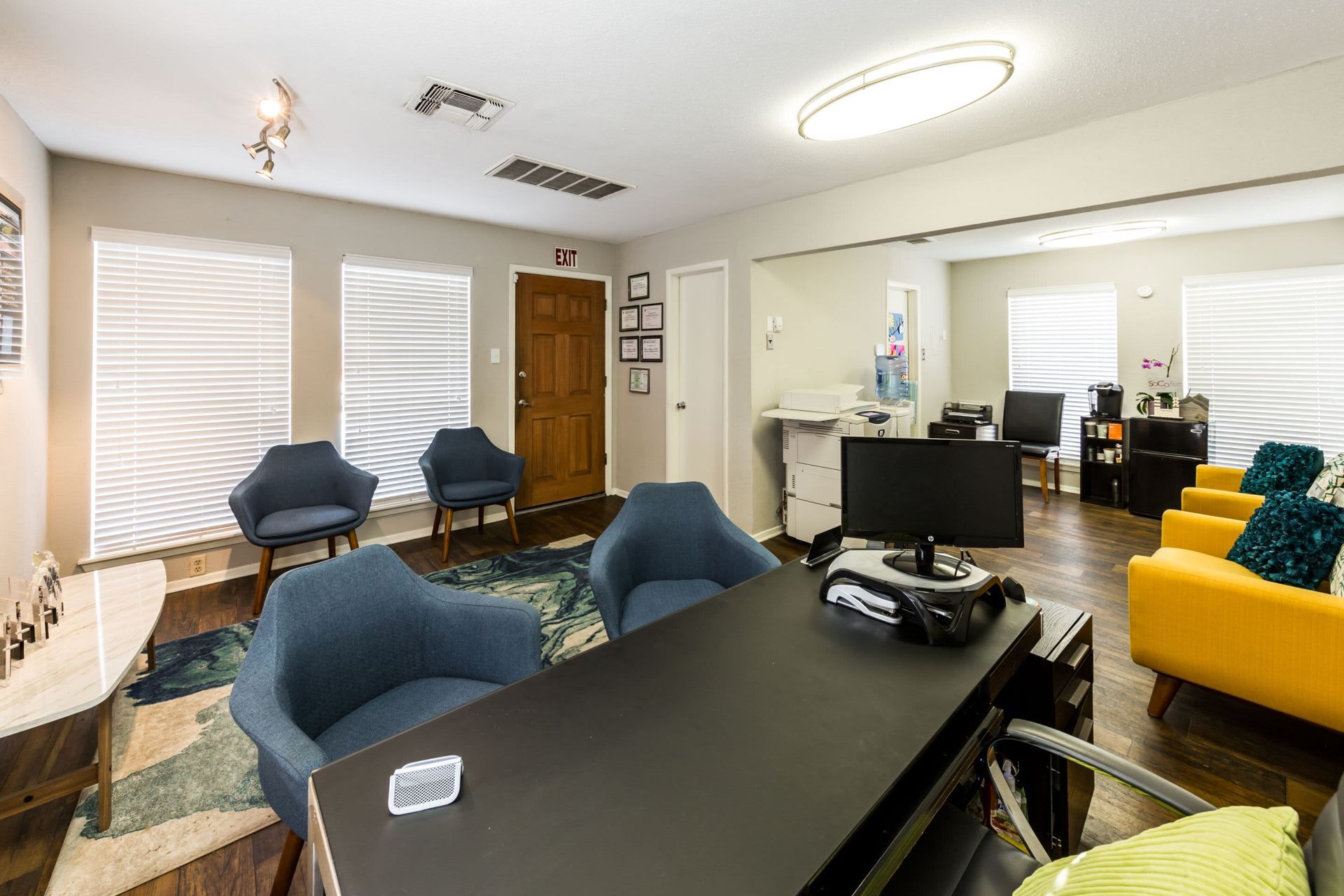 Apartment leasing office room with a desk, chairs, and a computer at SoCo on the Lake in Austin, TX.