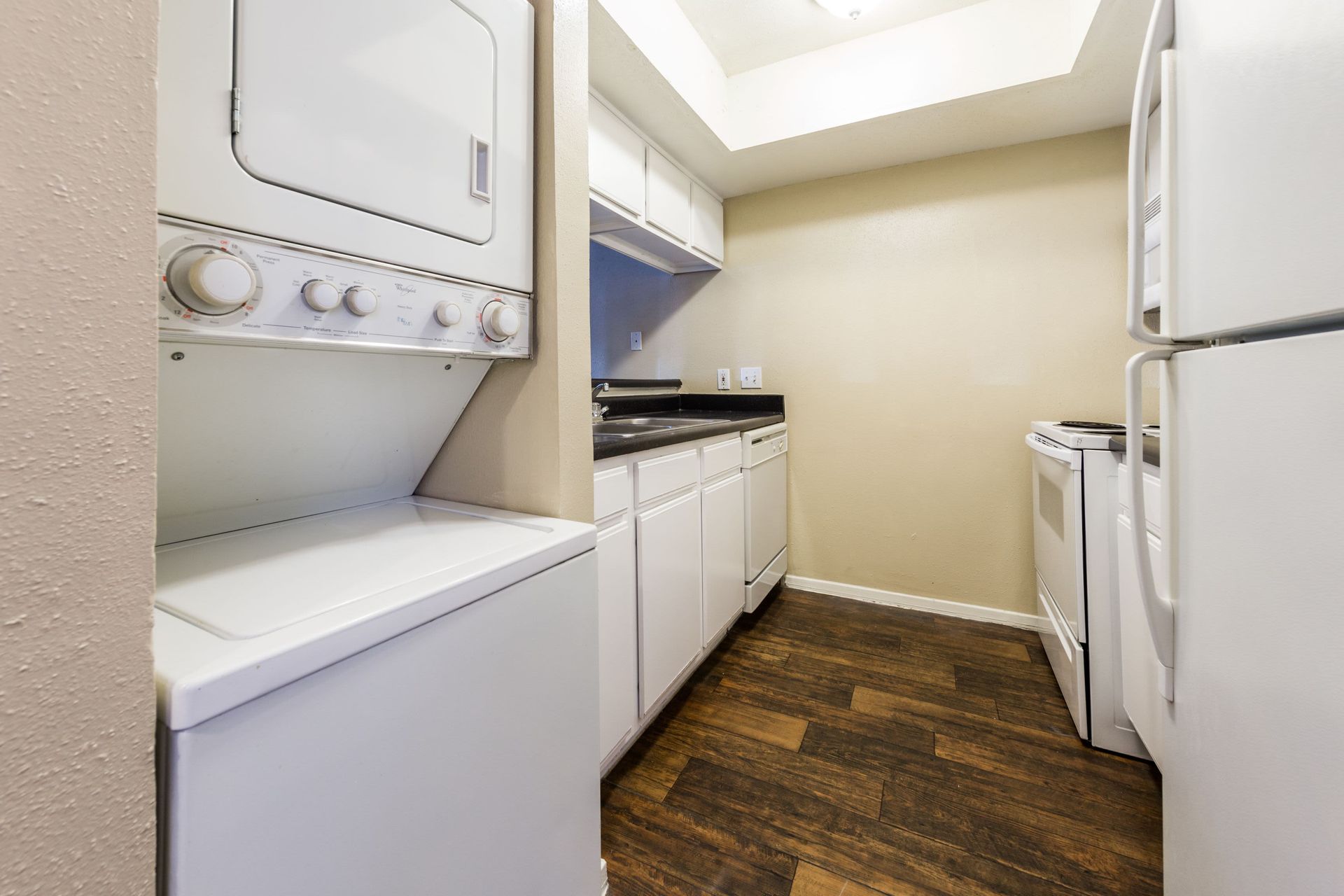 Apartment kitchen with a washer and dryer stacked on top of each other at SoCo on the Lake in Austin, TX.