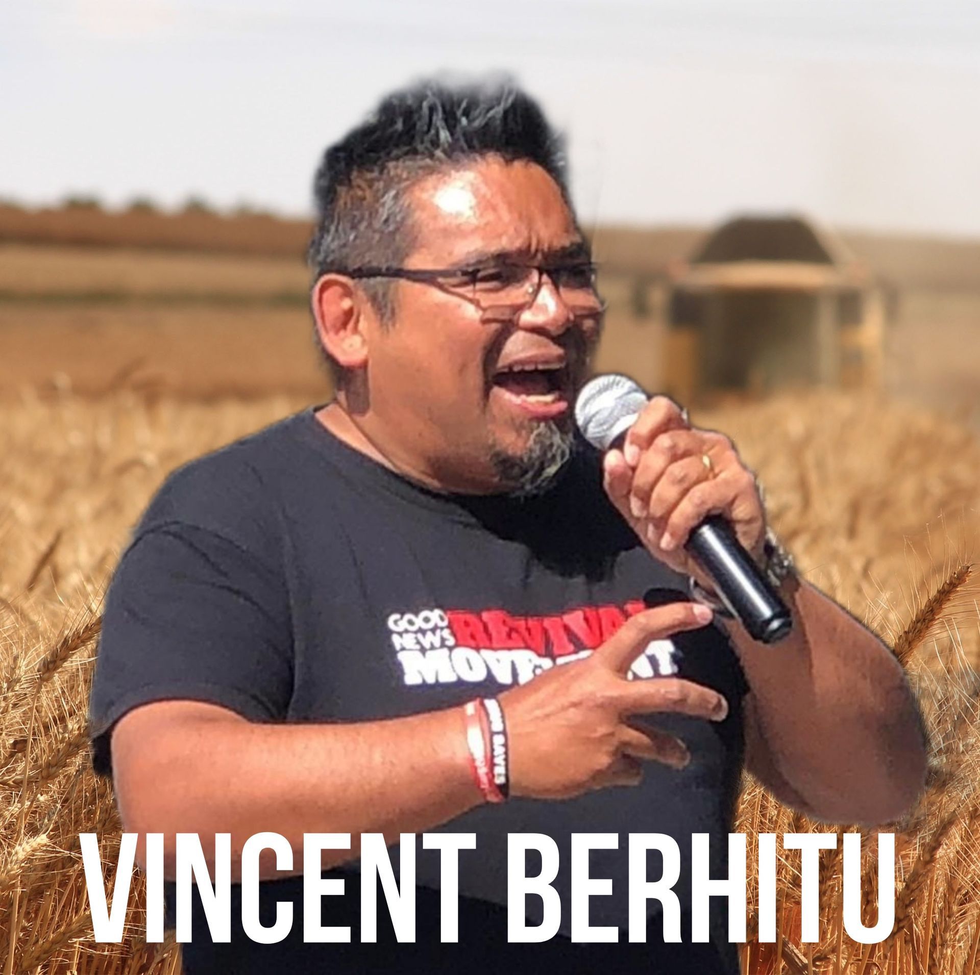 Vincent Berhitu spreekt in een microfoon in een tarweveld.