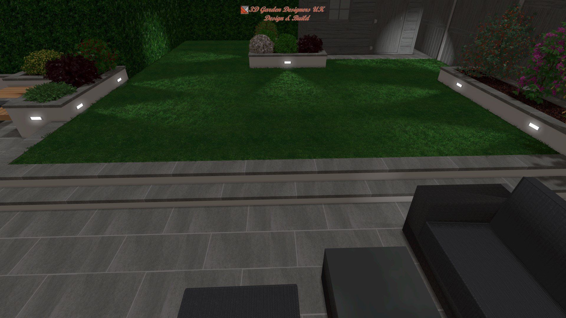 Outdoor patio with gray tile flooring, green grass, and low-lit garden beds.