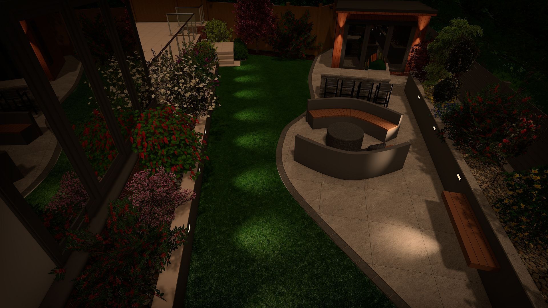 Nighttime backyard with illuminated lawn, patio, seating area, and landscaping.