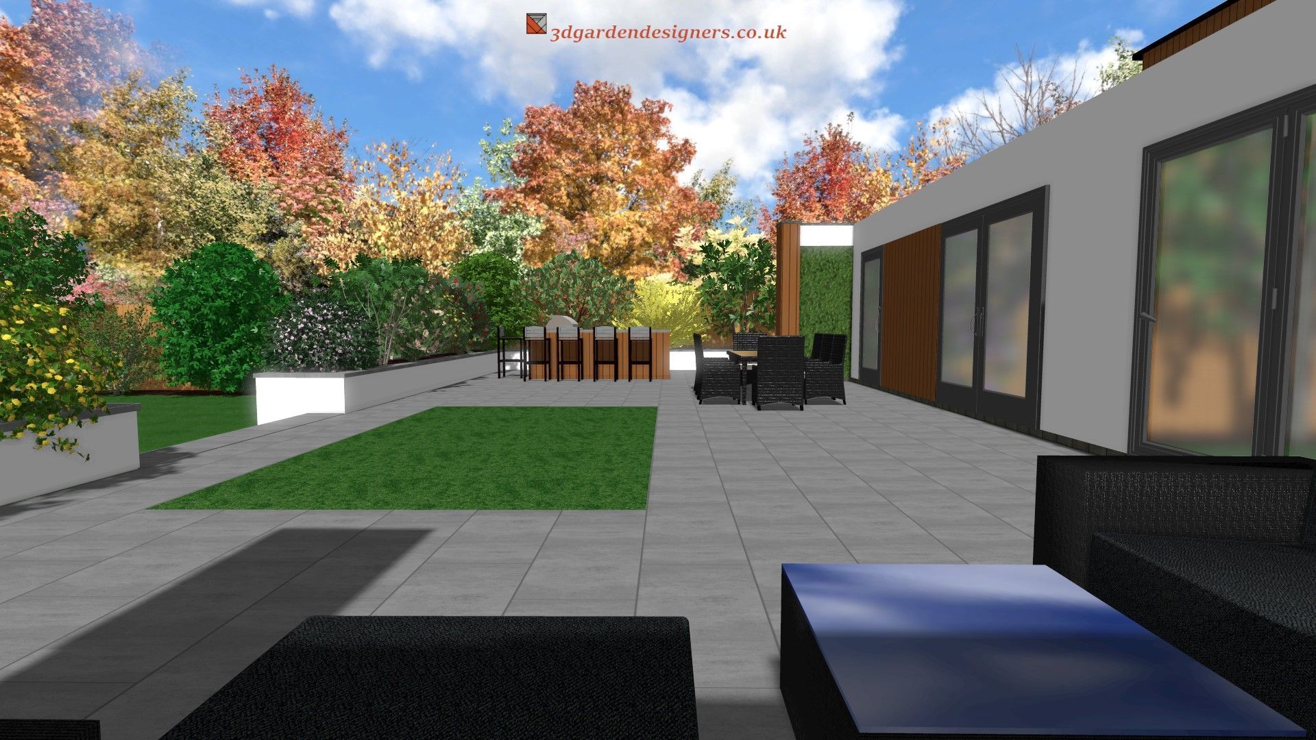 A modern patio design featuring a green lawn, seating area, and colorful autumn trees.