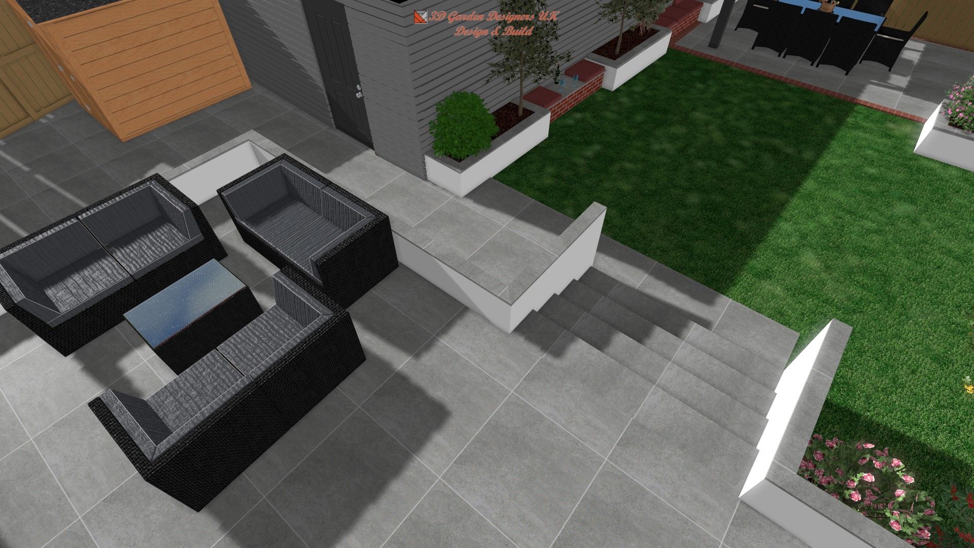 Outdoor patio with gray furniture, steps, lawn, and flower beds.