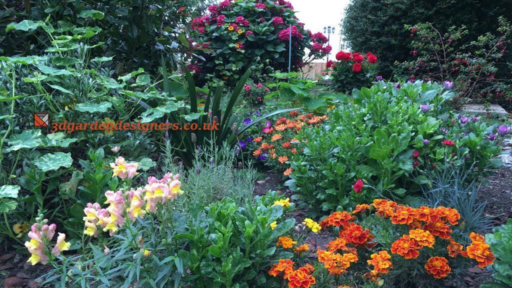 Lush garden with colorful flowers, including orange marigolds and yellow snapdragons, surrounded by green foliage.