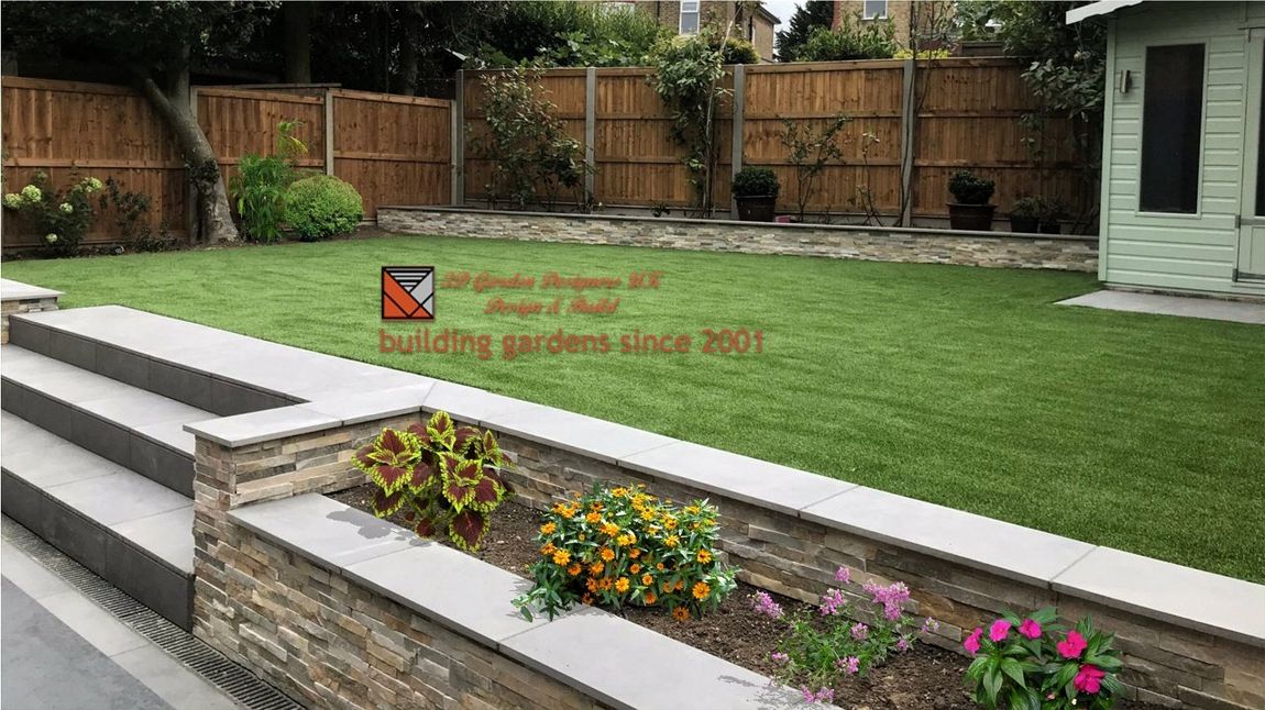 A tiered garden with stone steps, a flower bed, and a green lawn. Wooden fence in the background.