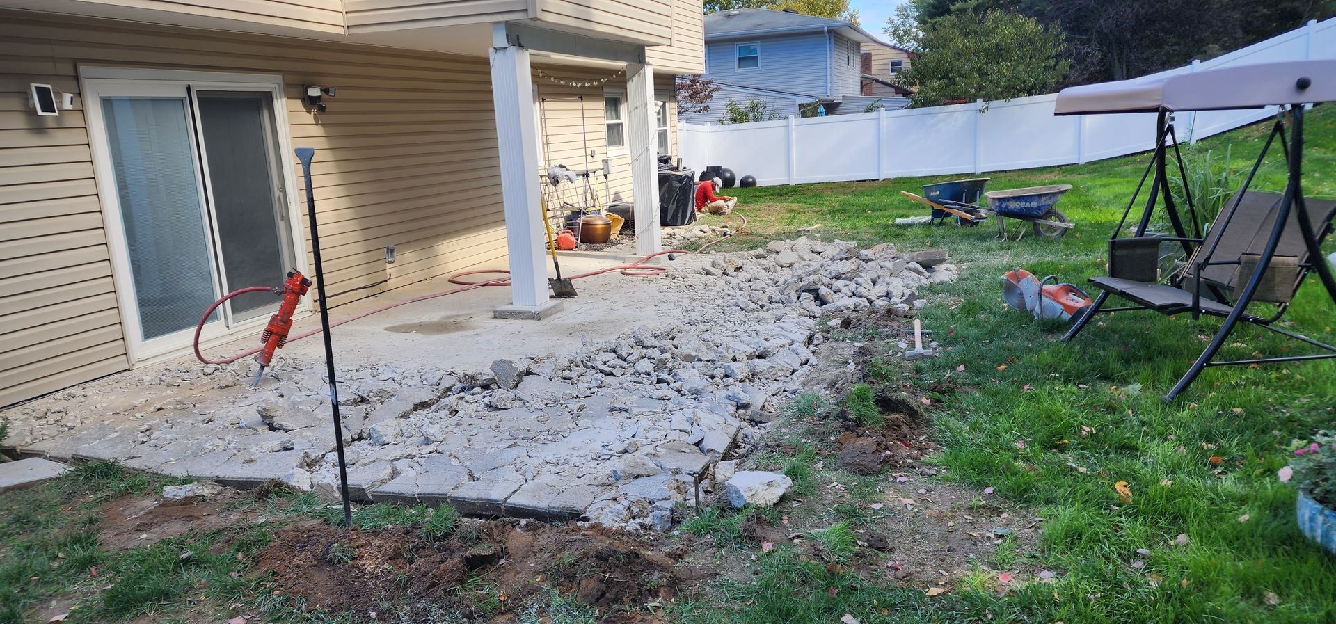 A patio is being built in the backyard of a house.