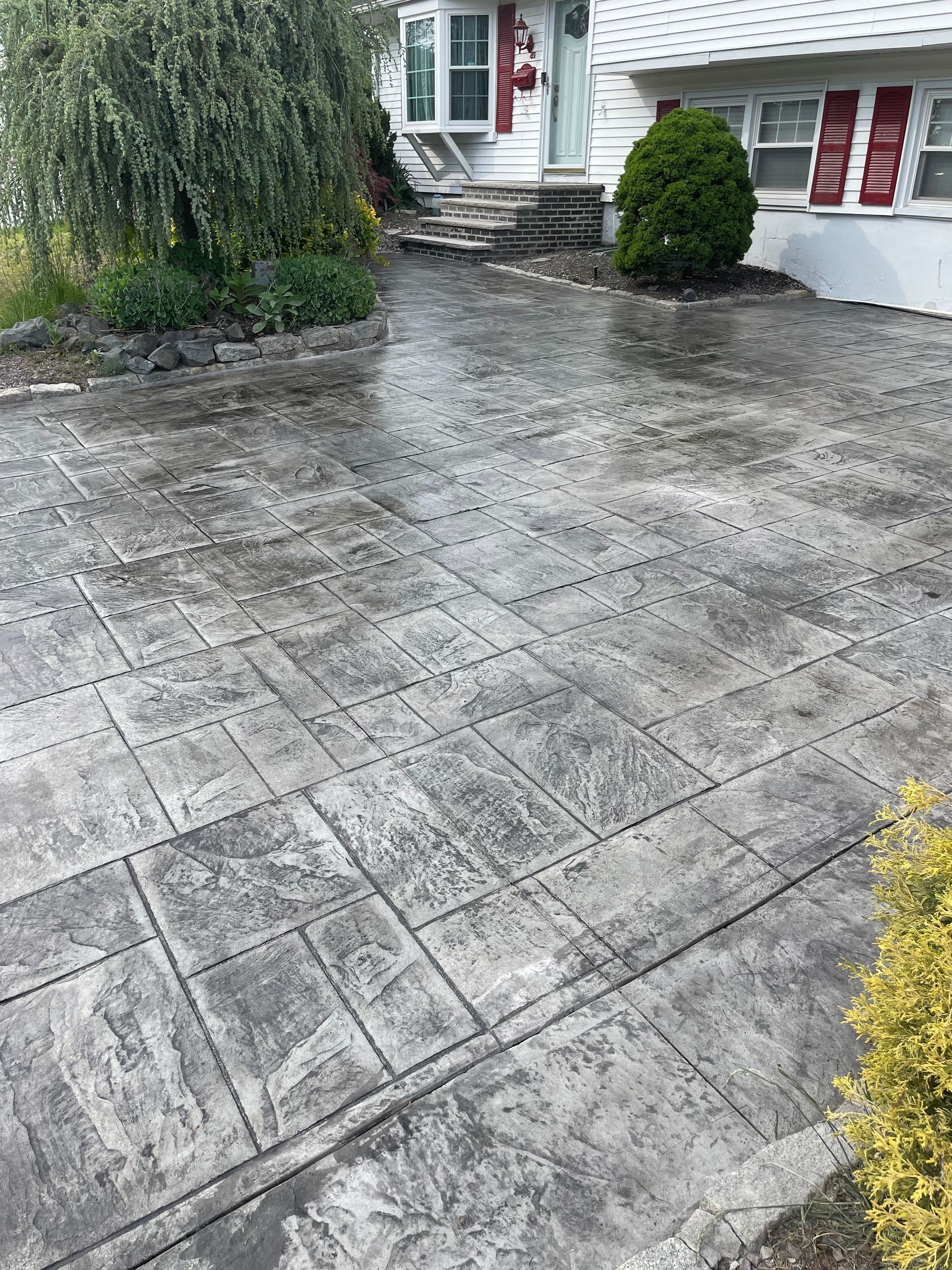 A concrete driveway in front of a house.