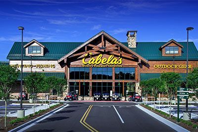 A cabela 's store with cars parked in front of it