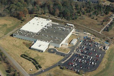 An aerial view of a large building with a parking lot in front of it