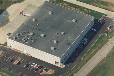 An aerial view of a large building with a parking lot in front of it