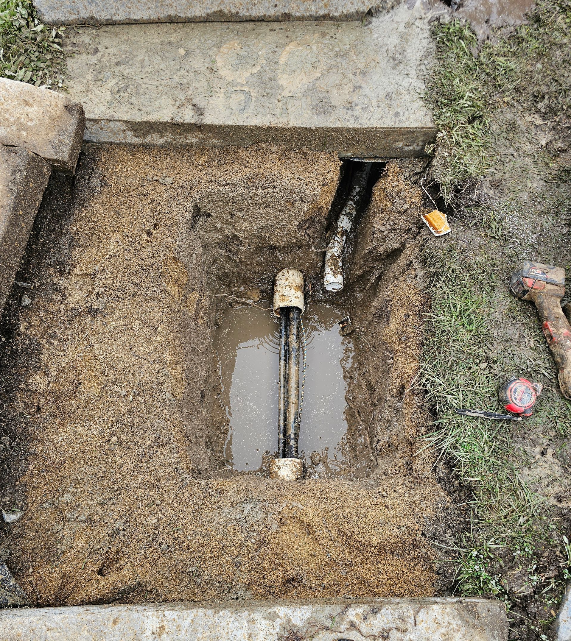 A Manhole Cover Is Being Installed In A Yard Next To A Fence — ViperVac Solutions PTY LTD in Cannonvale, QLD