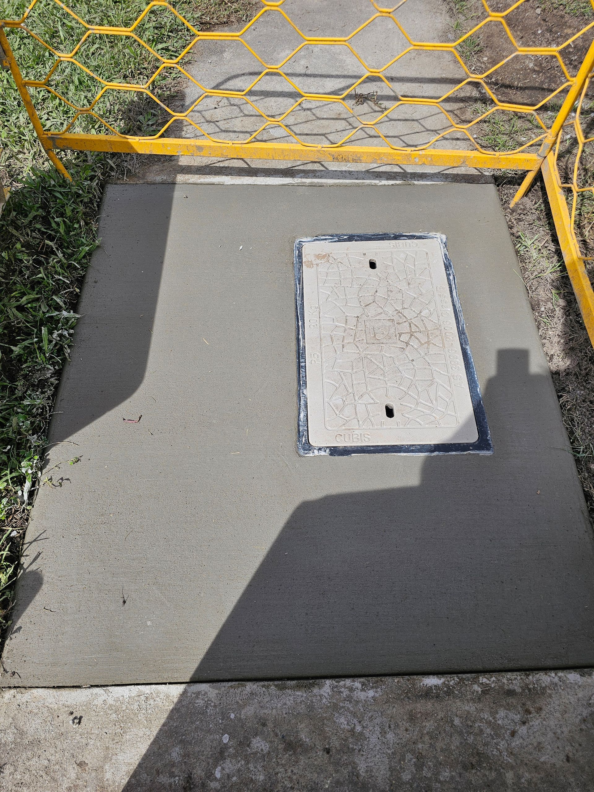 A Manhole Cover Is Sitting On Top Of A Concrete Sidewalk — ViperVac Solutions PTY LTD in Cannonvale, QLD