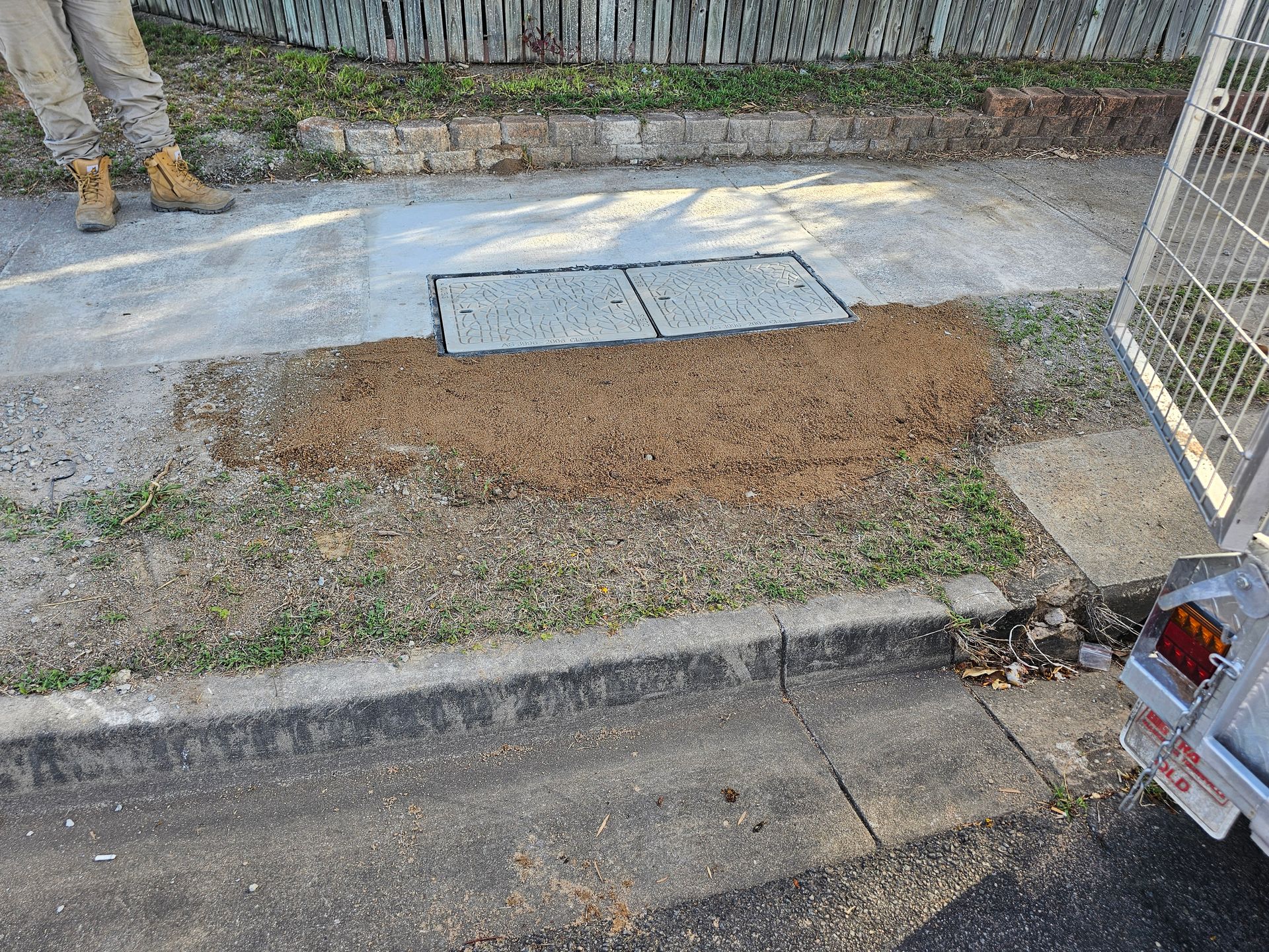 A Manhole Cover Is Sitting On Top Of A Concrete Sidewalk — ViperVac Solutions PTY LTD in Cannonvale, QLD