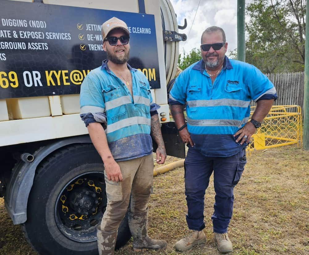 Two Men Are Standing Next To Each Other In Front Of A Truck — ViperVac Solutions PTY LTD in Cannonvale, QLD