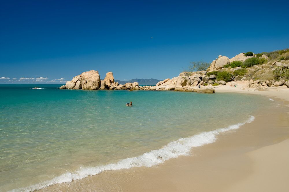 A Couple Of People Are Swimming In The Ocean On A Beach — ViperVac Solutions PTY LTD in Bowen, QLD