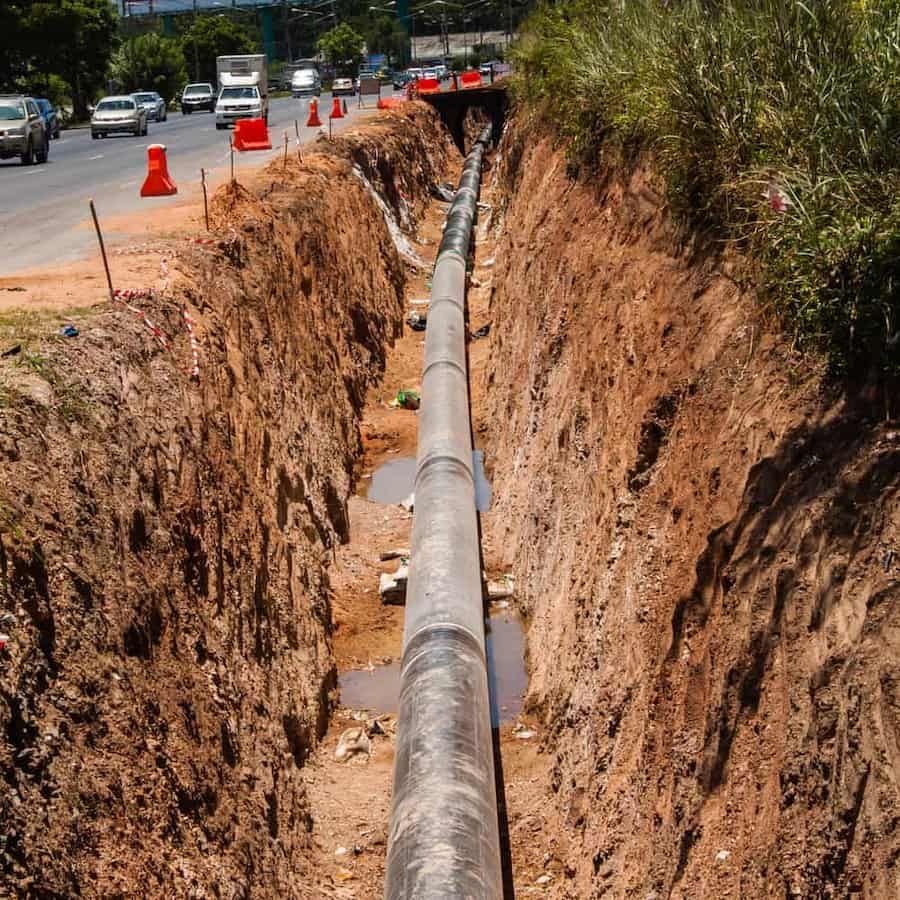 A Large Pipe Is Being Installed In A Trench Next To A Road — ViperVac Solutions PTY LTD in Cannonvale, QLD