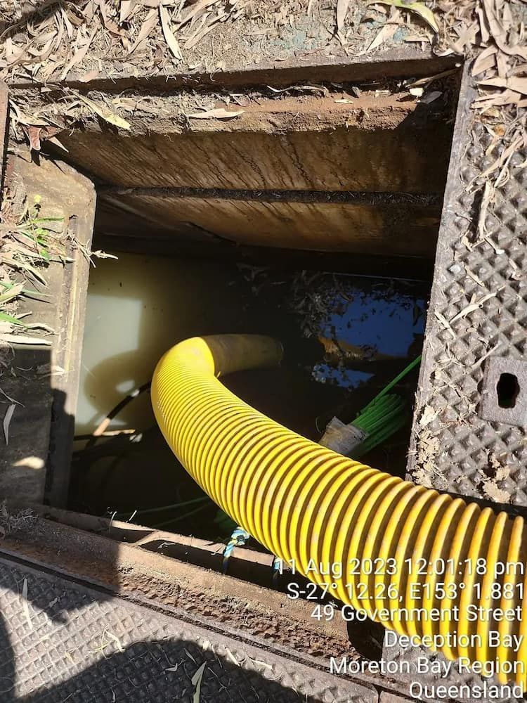A Yellow Hose Is Coming Out Of A Manhole Cover — ViperVac Solutions PTY LTD in Cannonvale, QLD