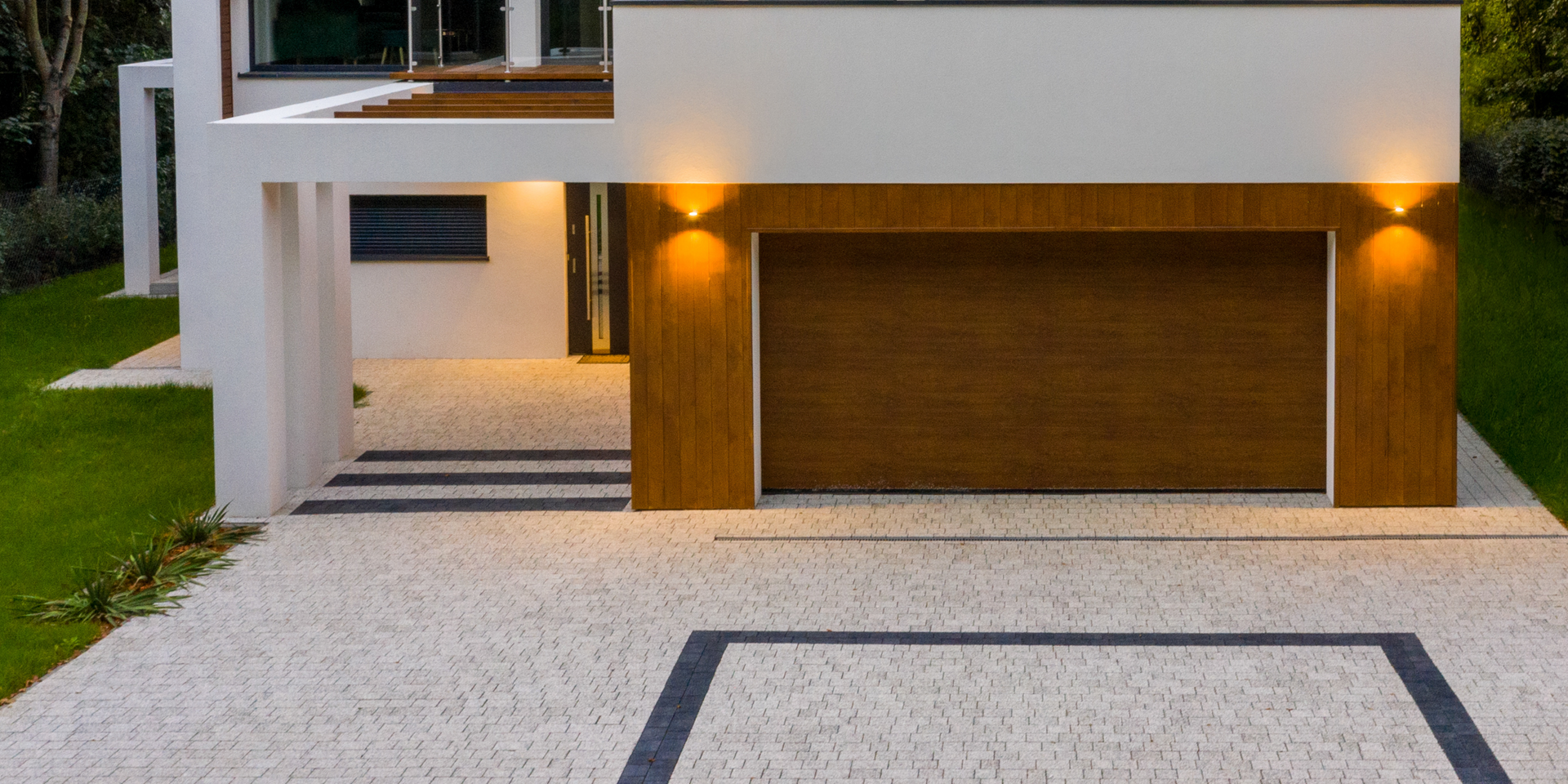 Modern house exterior with wooden garage door and paved driveway.