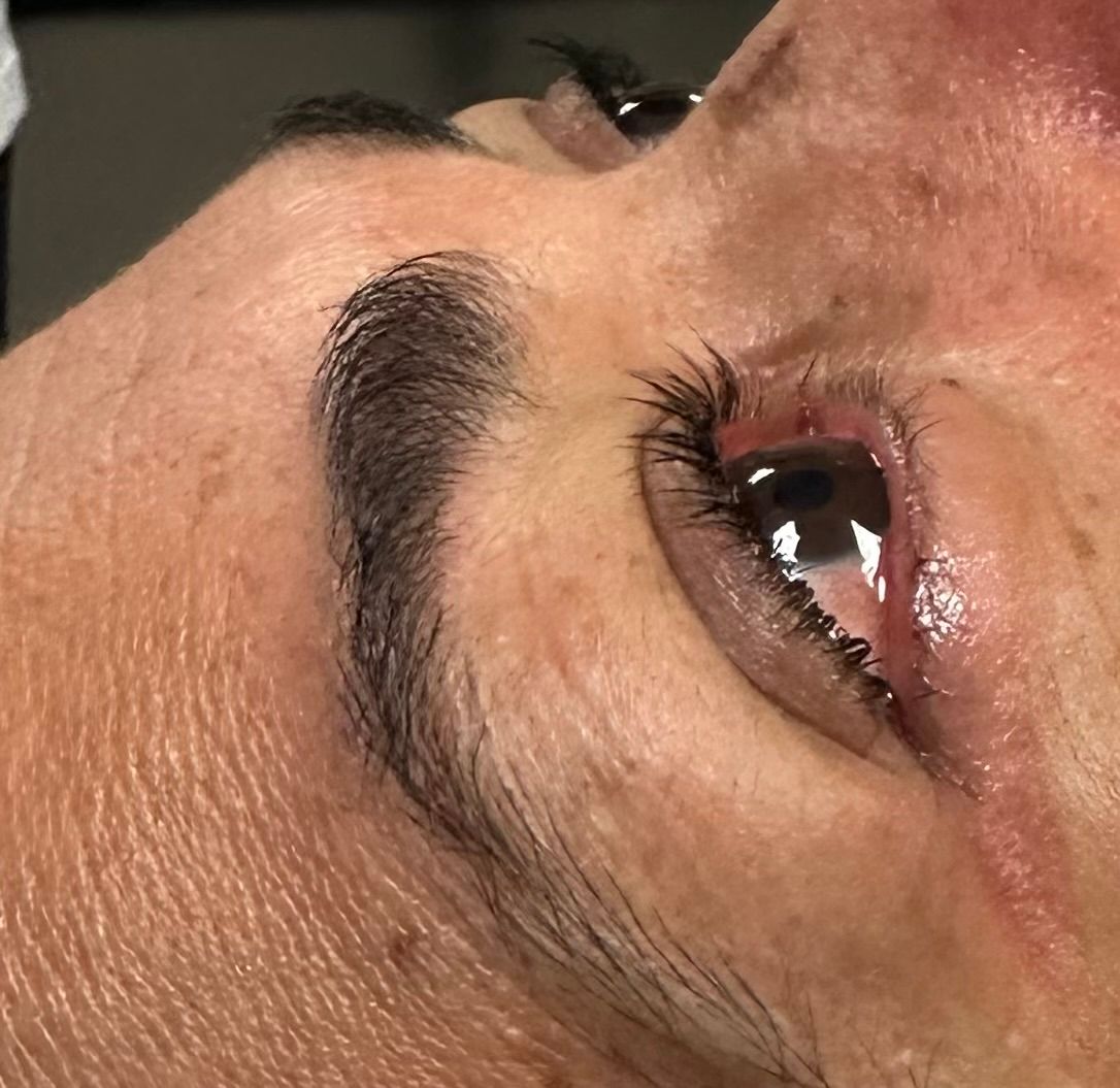 Close-up of a person's eye, with a tear and a raised eyebrow.