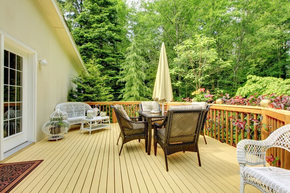A Wooden Deck With a Table and Chairs — D.J. Decks in Urunga, NSW