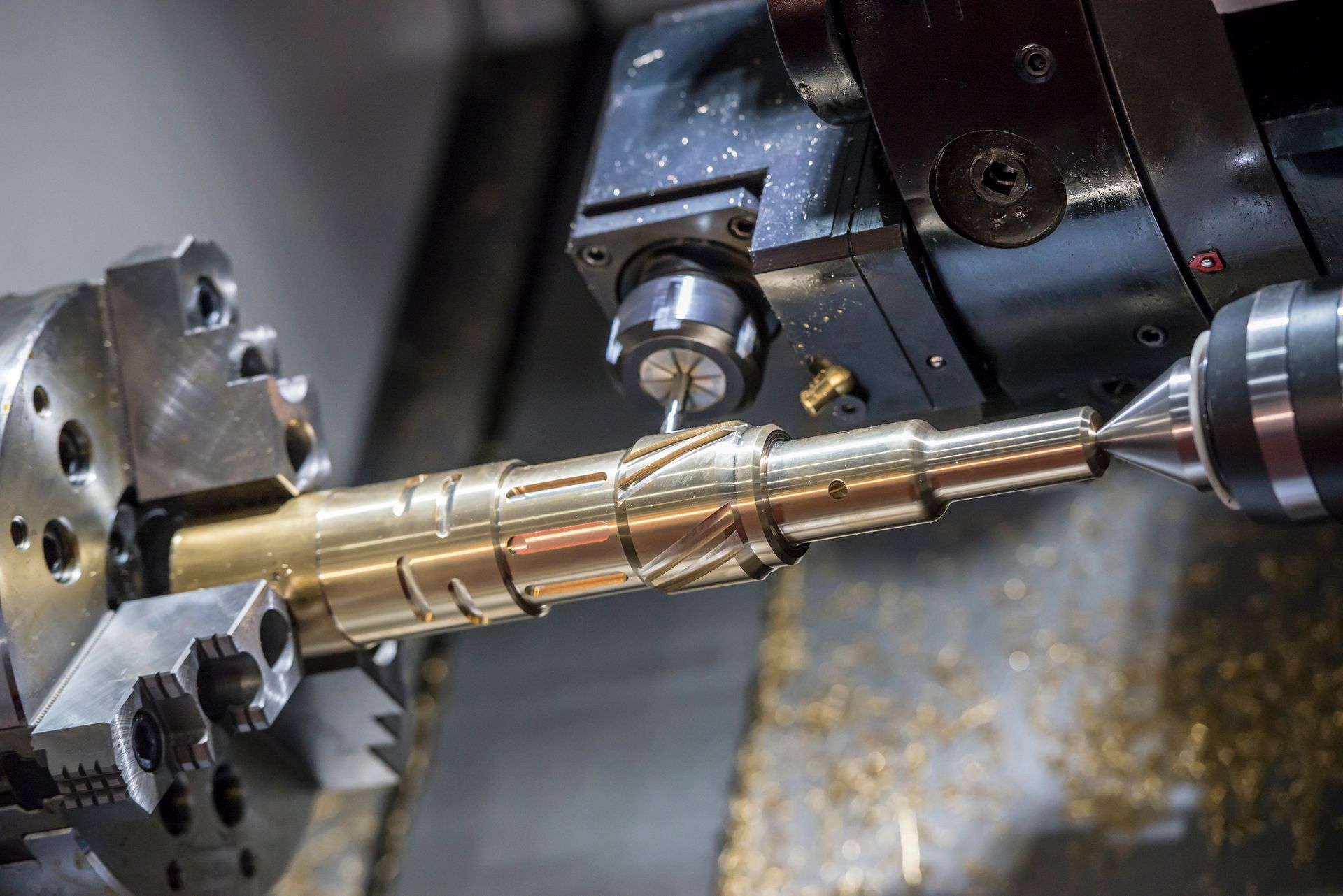 A machine is cutting a piece of metal on a lathe.
