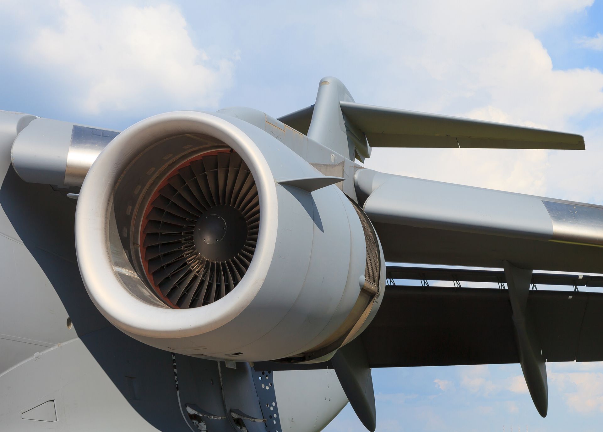 A close-up of an airplane engine with a blue sky in the background.