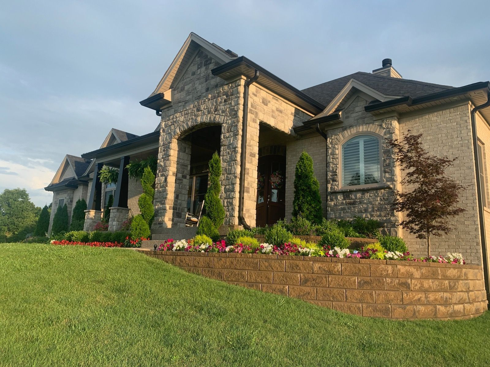 A large brick house with a lush green lawn in front of it.
