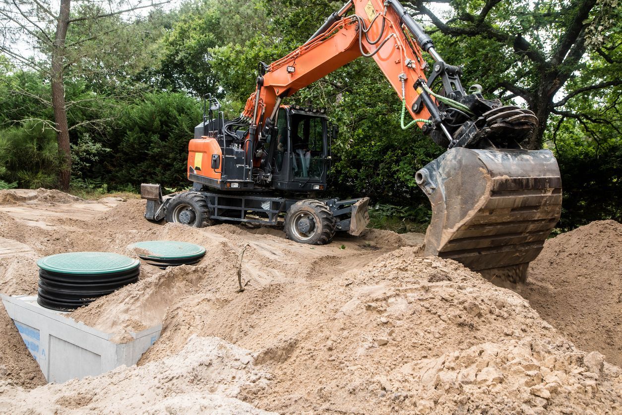 Orange excavator digging a sandy trench beside green utility covers in a wooded area