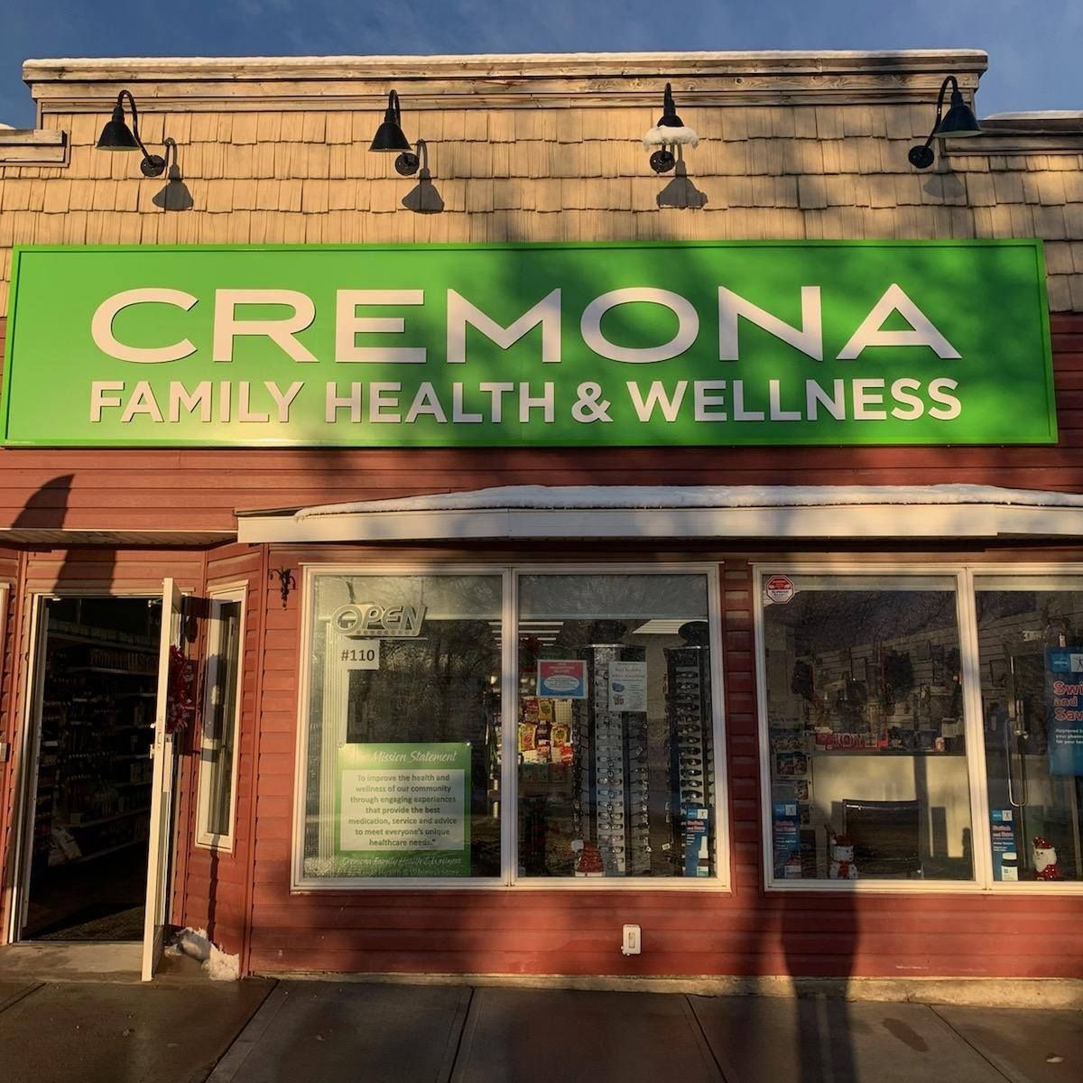The storefront for Cremona Family Health & Wellness, featuring a prominent green sign above large display windows.