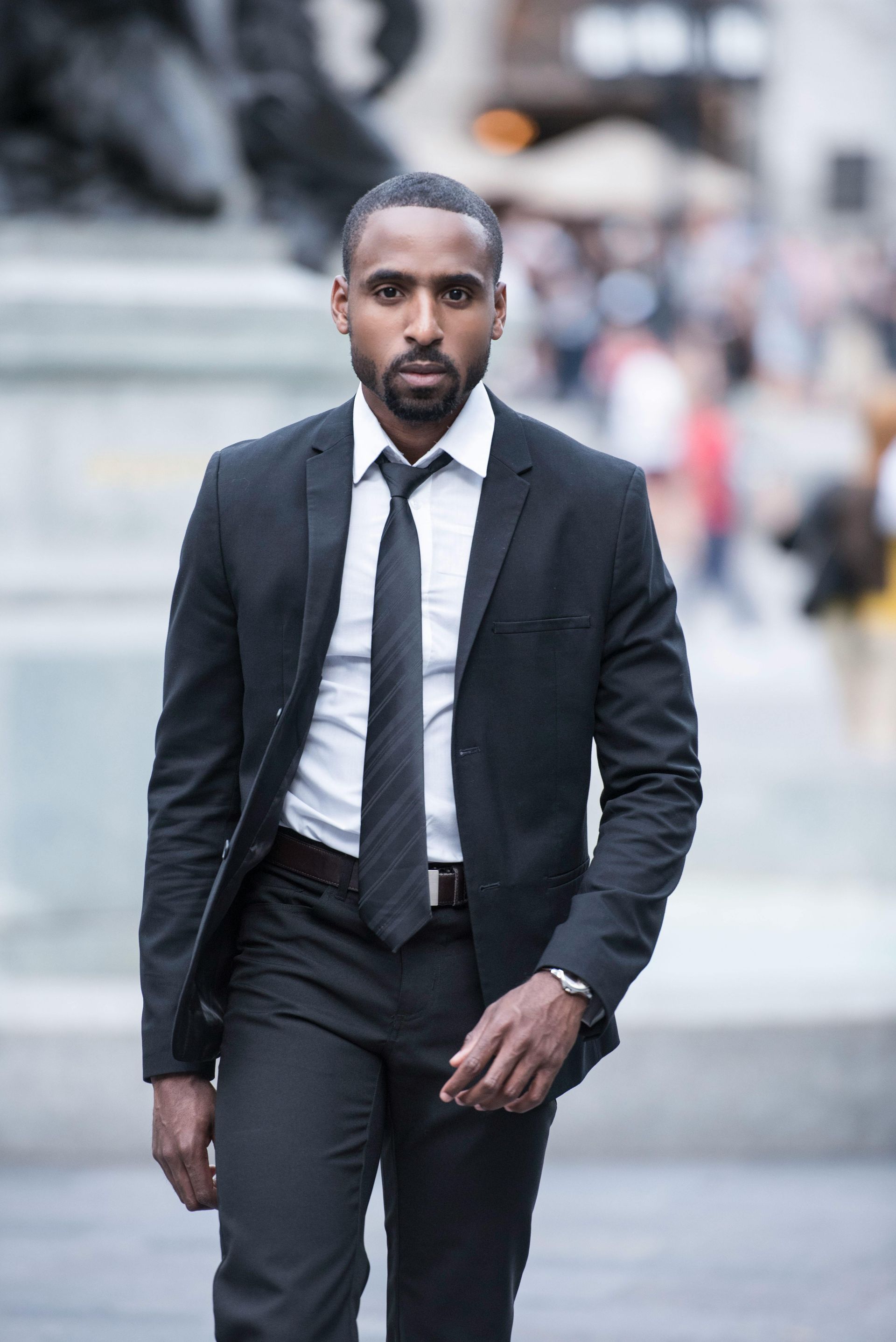 A man in a suit and tie is walking down the street