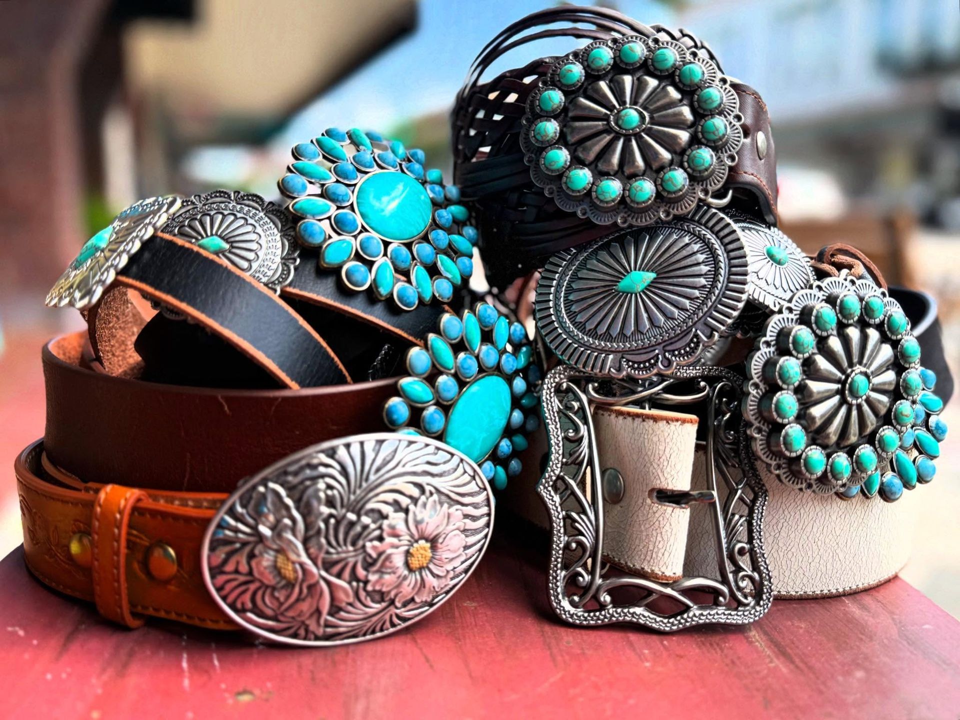Leather belt and matching silver, turquoise-studded western accessories on a soft surface.