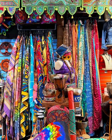 Colorful market stall packed with patterned scarves and textiles hanging in dense rows