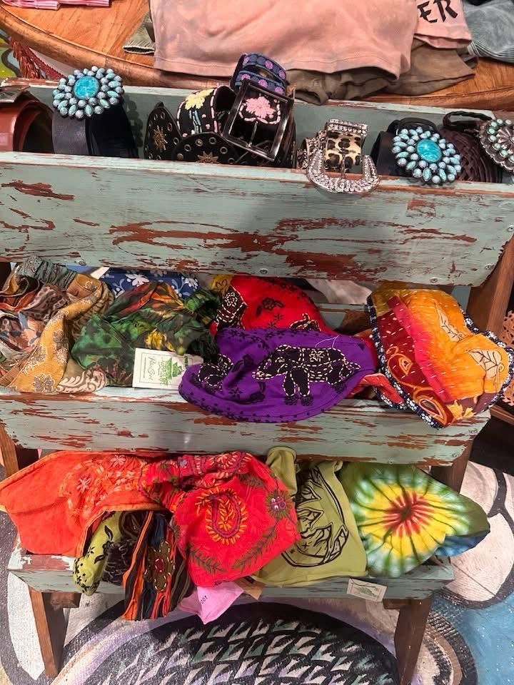 Colorful tie-dye bandanas and headbands displayed on weathered wooden shelves.
