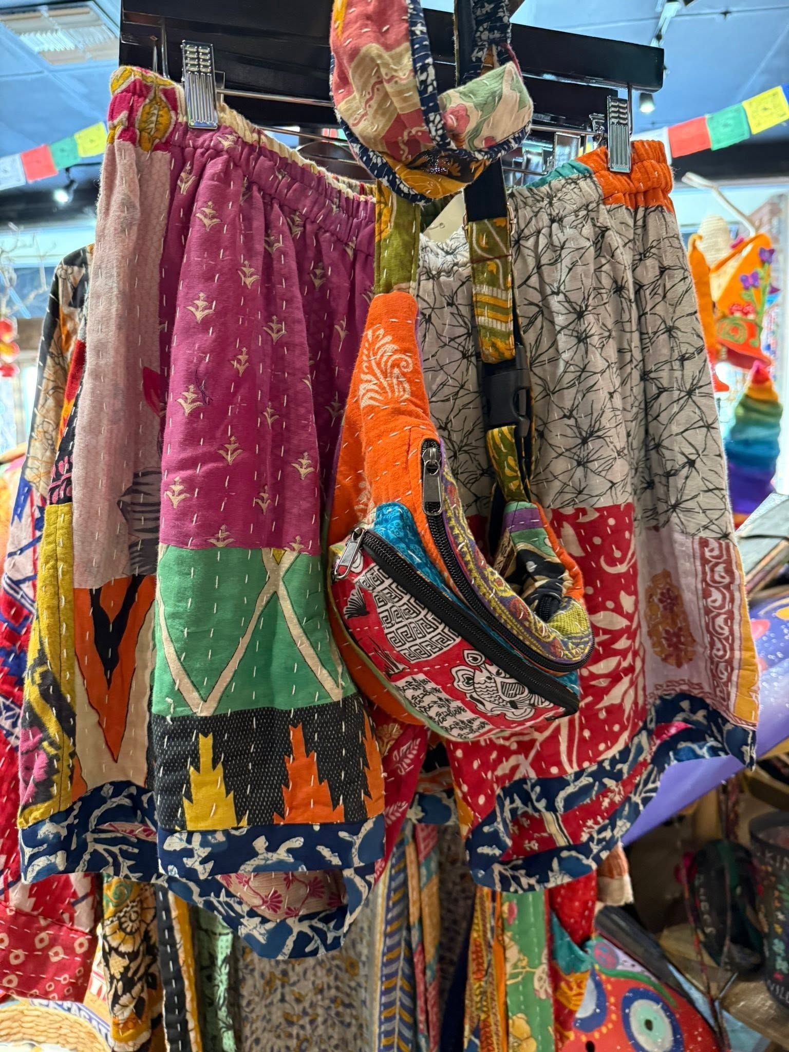 Colorful embroidered dresses hanging on display at a clothing market stall