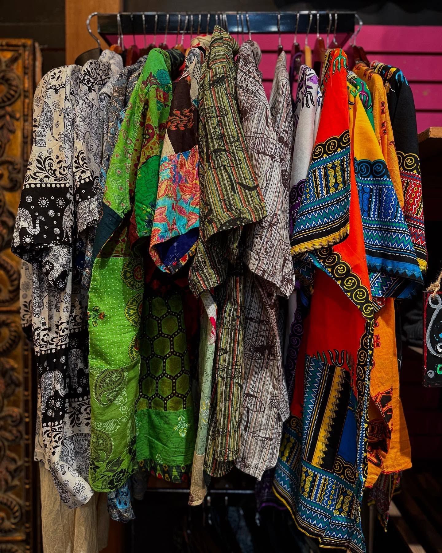 Colorful patterned scarves and shawls hanging on a display rack in a shop