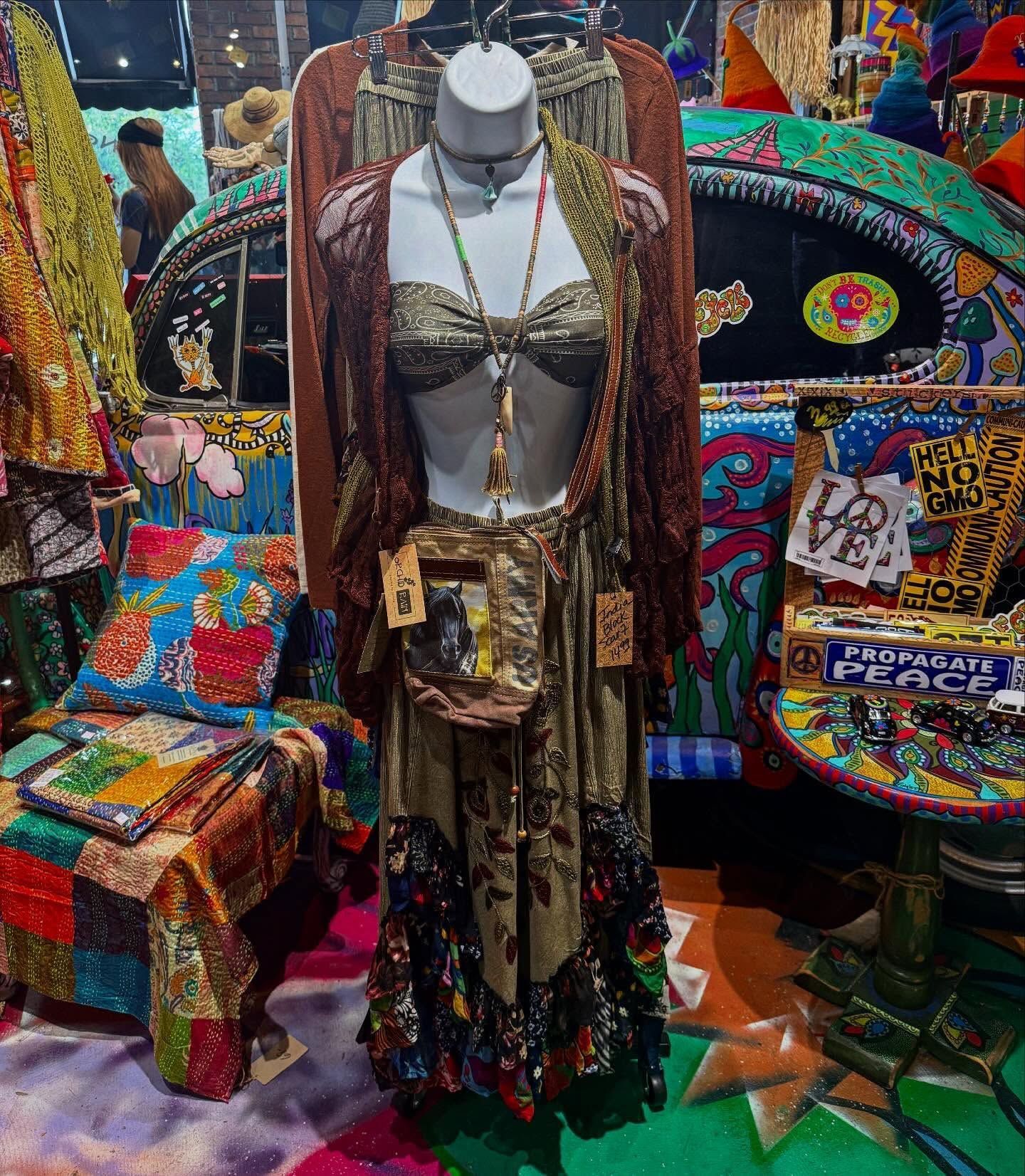 Mannequin in a colorful bohemian boutique, surrounded by patterned textiles and decor.
