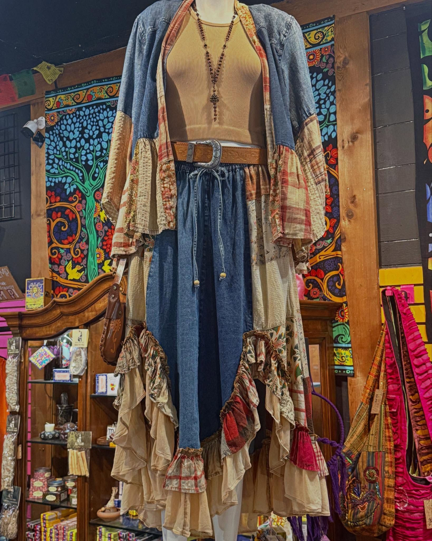 Long fringed blue-and-cream boho dress displayed on a mannequin in a colorful boutique.