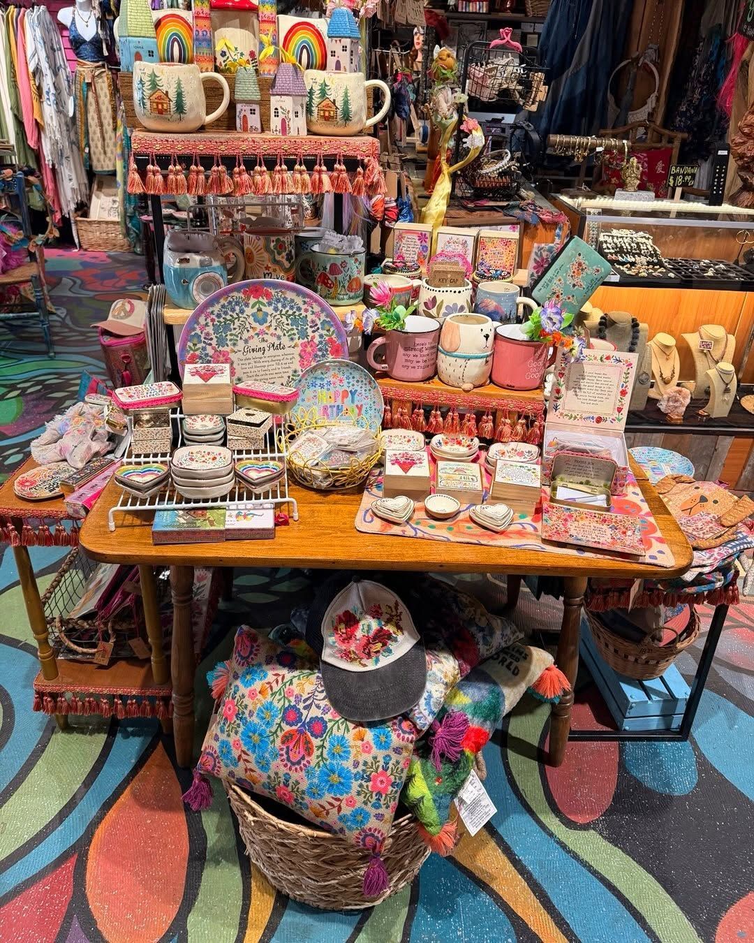 Colorful display of handmade crafts, baskets, and trinkets on a table in a patterned market stall