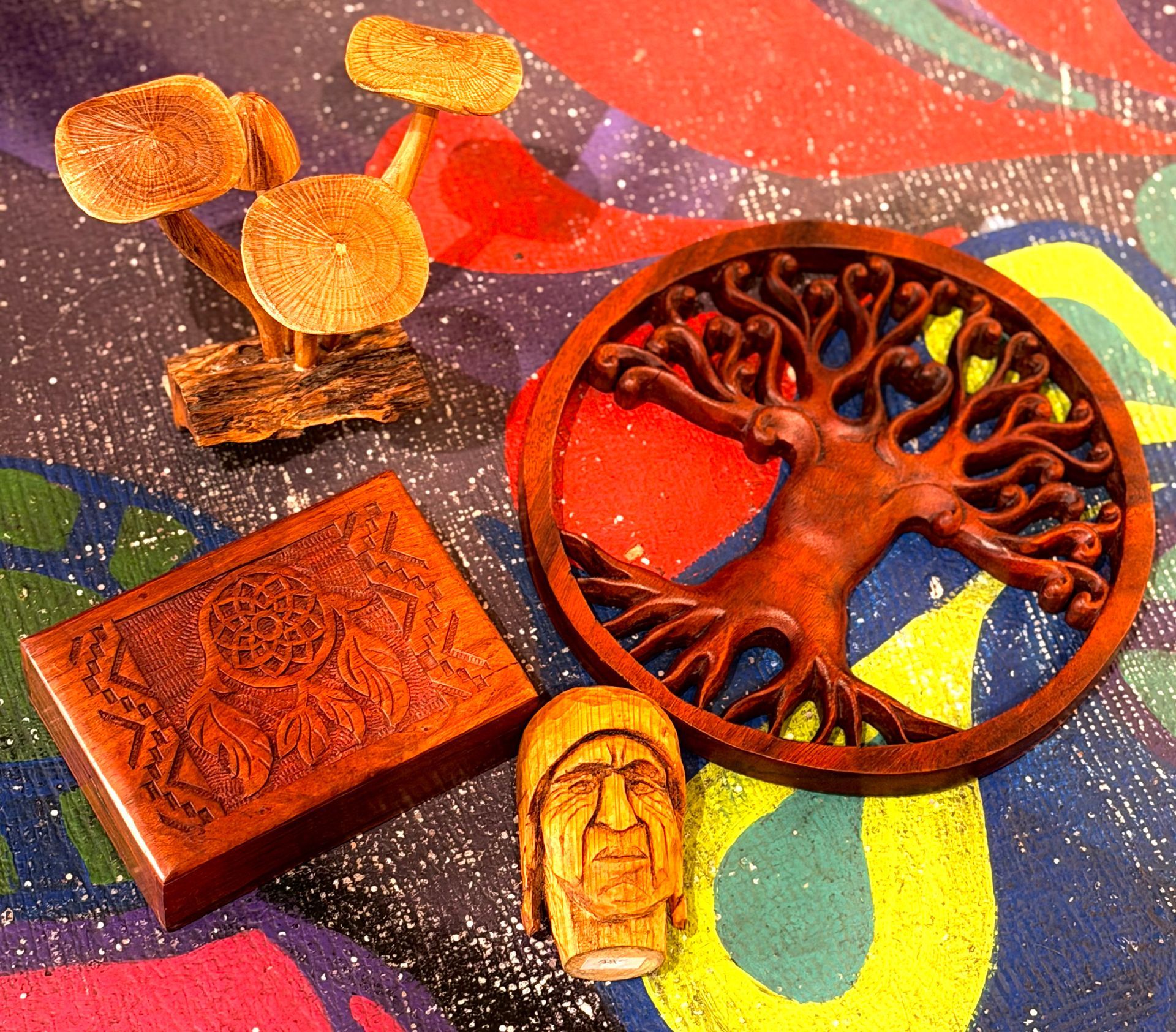 Assorted carved ornaments and a tree medallion on a colorful fabric background