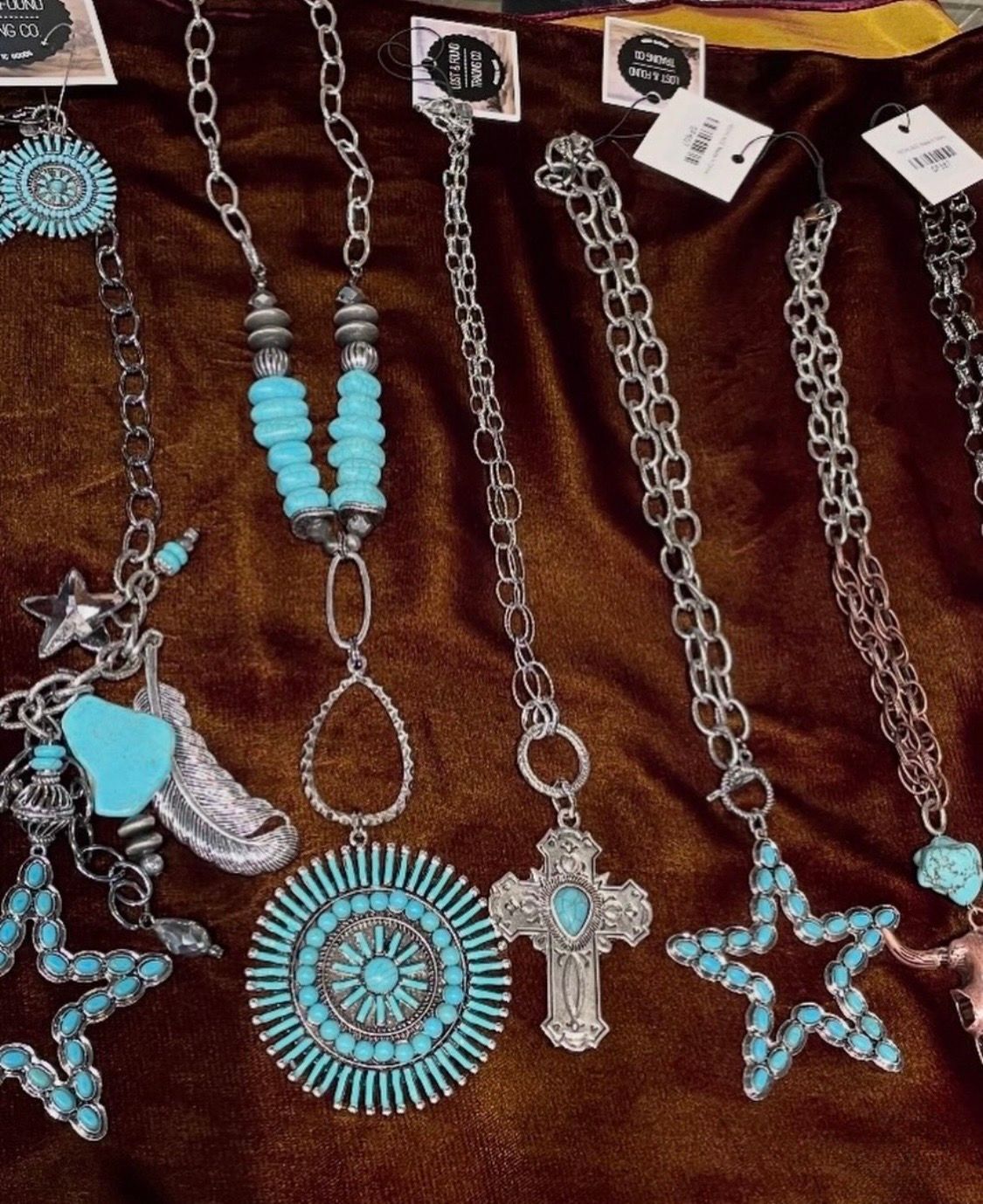 Assorted colorful dangling earrings displayed on a black velvet board