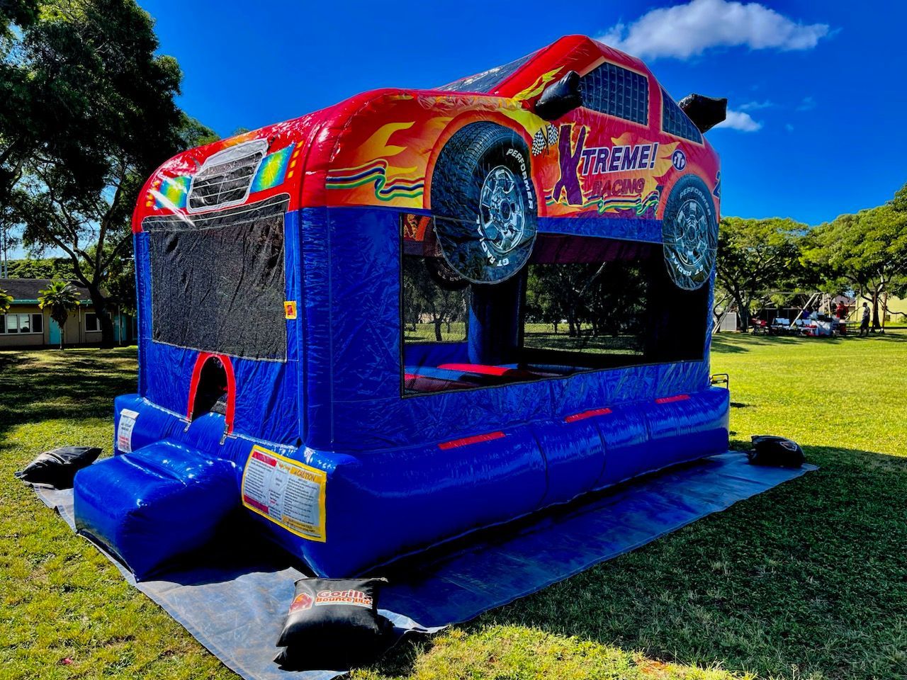 A blue and red bouncy house in the shape of a car.