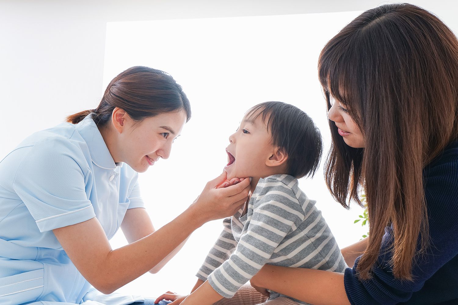 A Dentist checking the teeth of a toddler boy