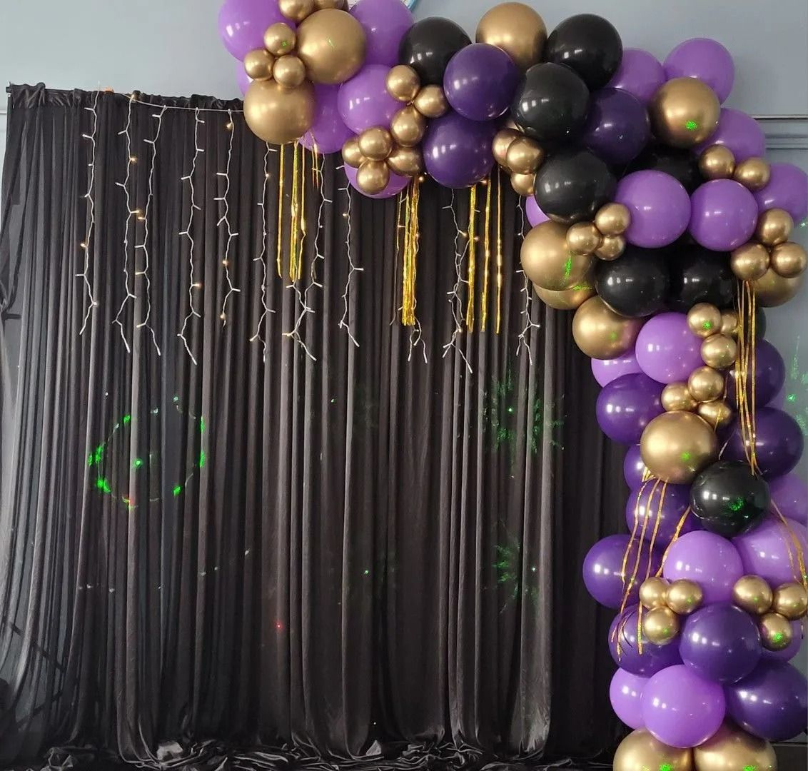 Purple, Gold, and Black Balloon Arch Over Black Curtains — Creative Events Innisfail in Innisfail, QLD