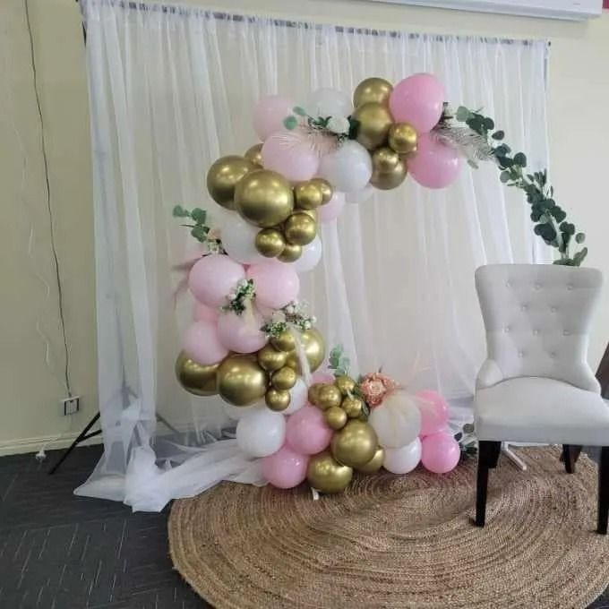 Balloon Arch With Pink, White, and Gold Balloons; a White Chair — Creative Events Innisfail in Tully, QLD