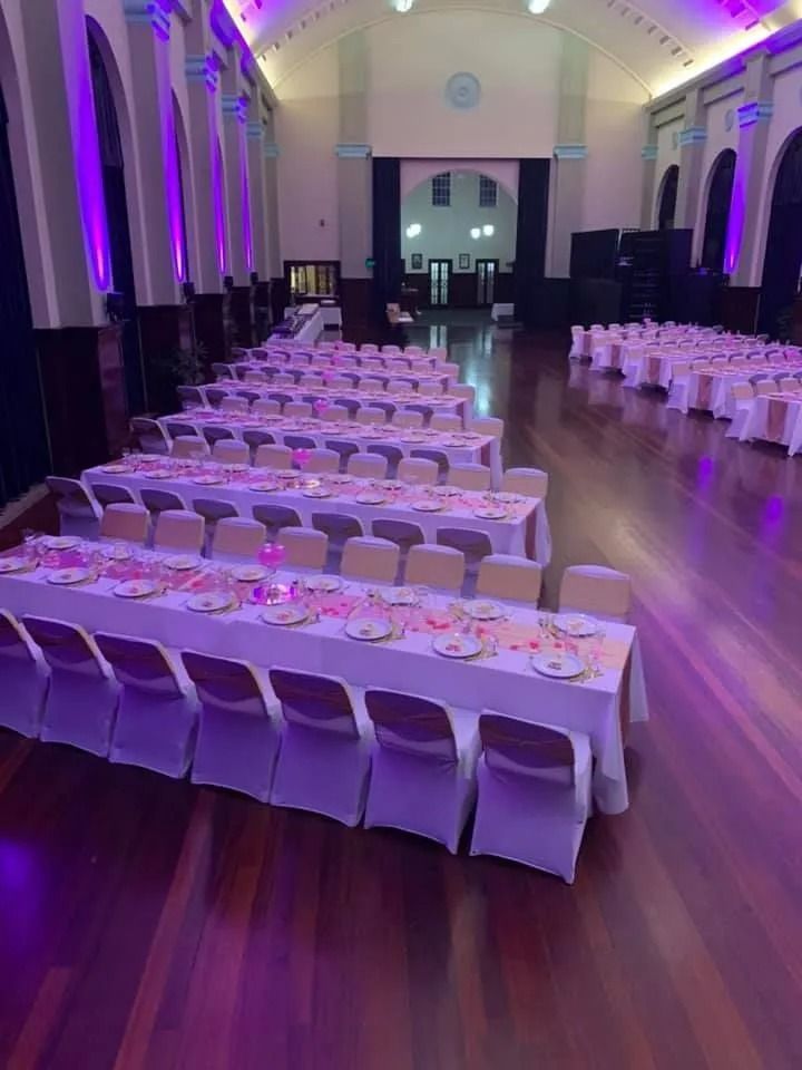 Long Tables Set for a Banquet in a Hall With Purple Uplighting — Creative Events Innisfail in Tully, QLD