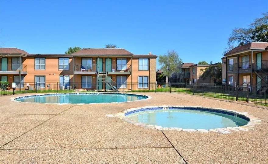 a large apartment building with a swimming pool in front of it .