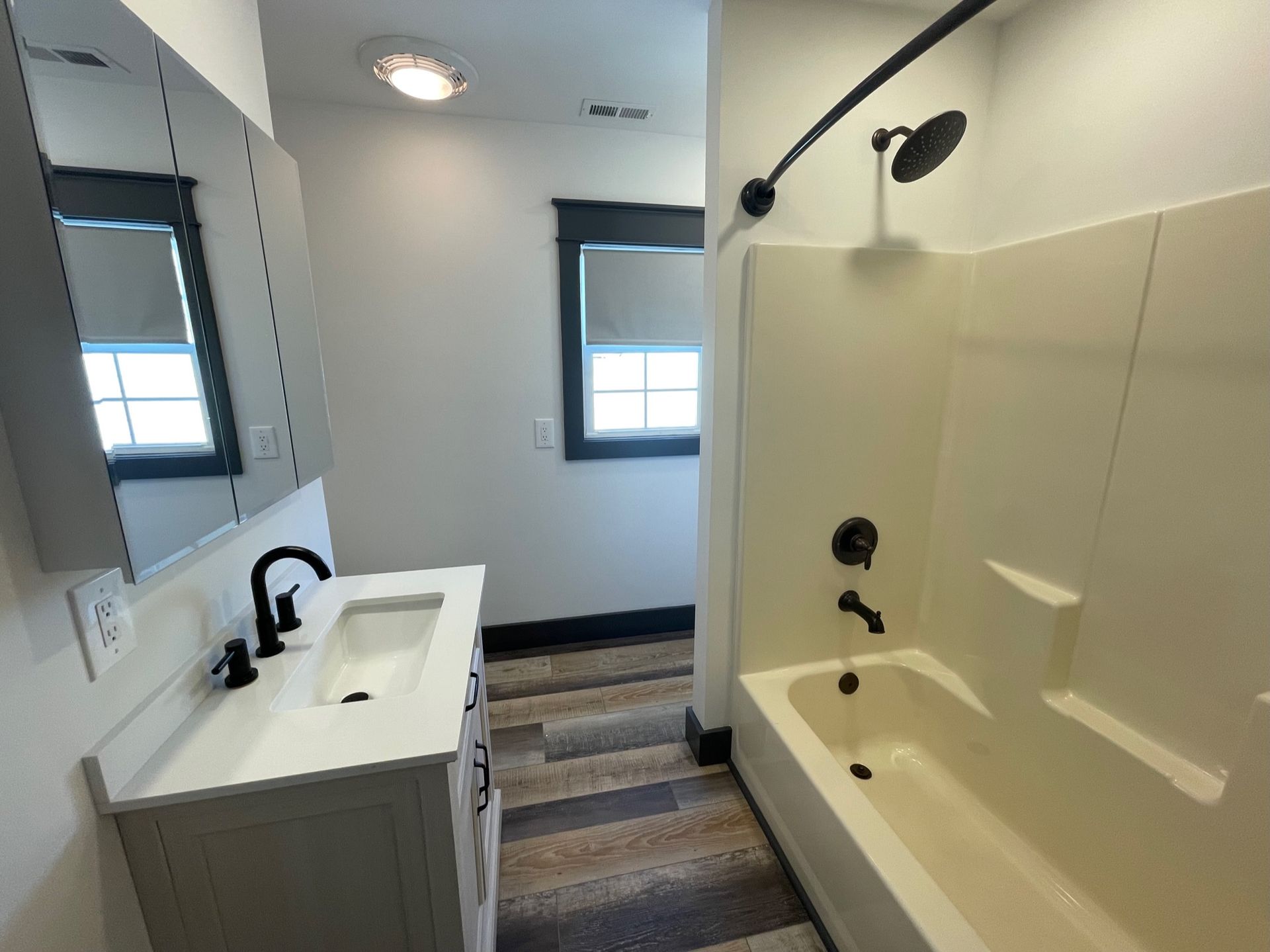 A bathroom with a sink , tub and shower.