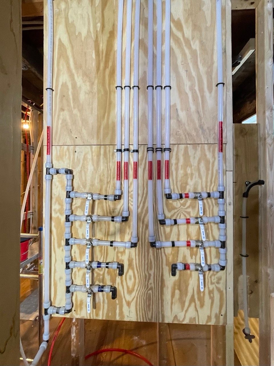 A bunch of pipes are hanging on a wooden wall