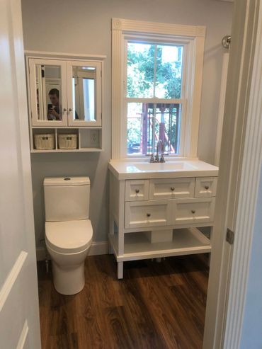 A bathroom with a toilet , sink and mirror